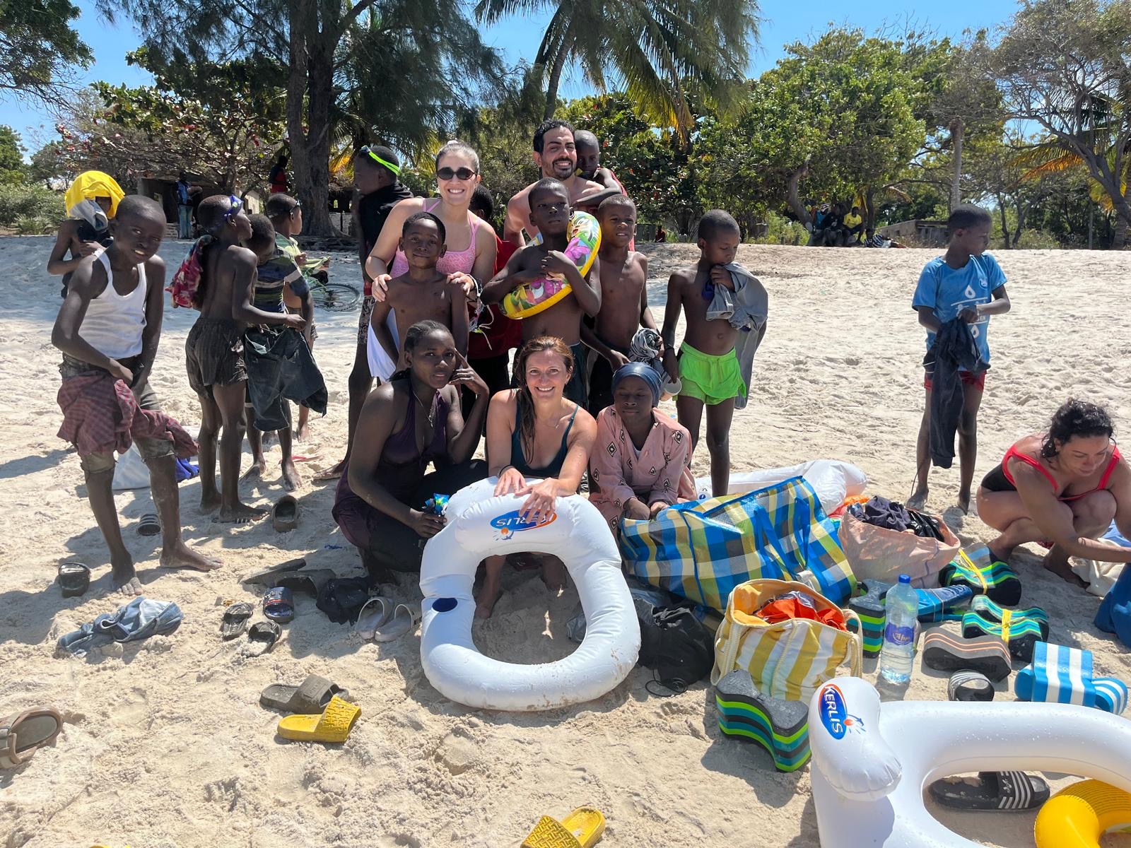 Enfants et équipe sur la plage pendant les activités de la mission humanitaire